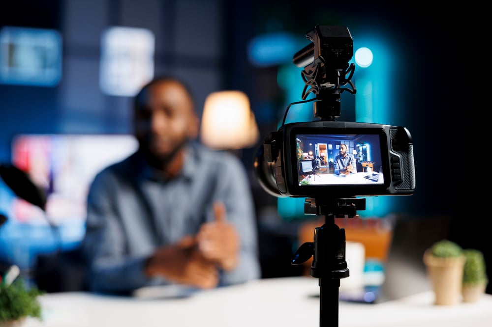 Man behind a camera filming a video advertisement